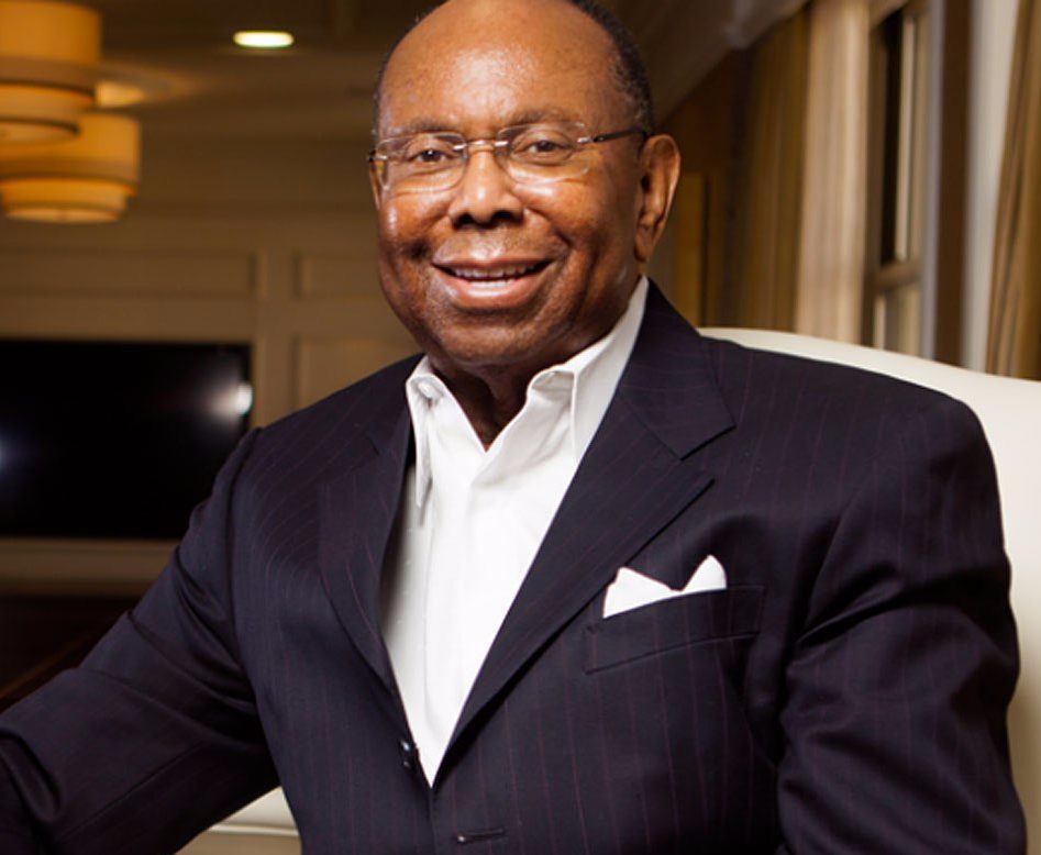 A man in a suit and tie smiling for the camera.